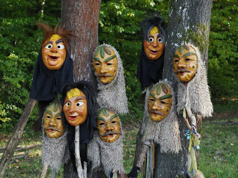 Masken der Ranzabuffer und Gerschdakender an einem Baumstamm