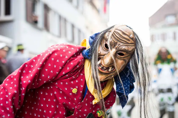 Hexe mit Holzmaske in rot gepunkteter Bluse