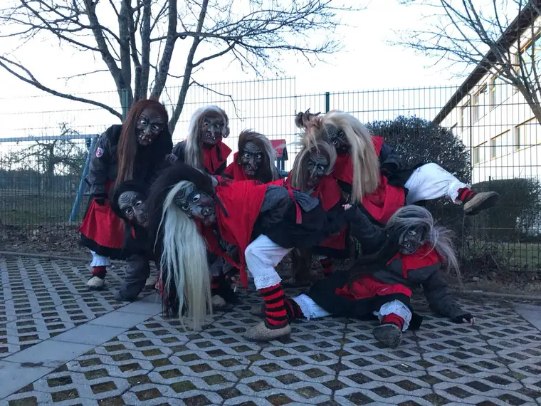Richtplatzhexen mit rot-schwarzen Stulpen und Besen