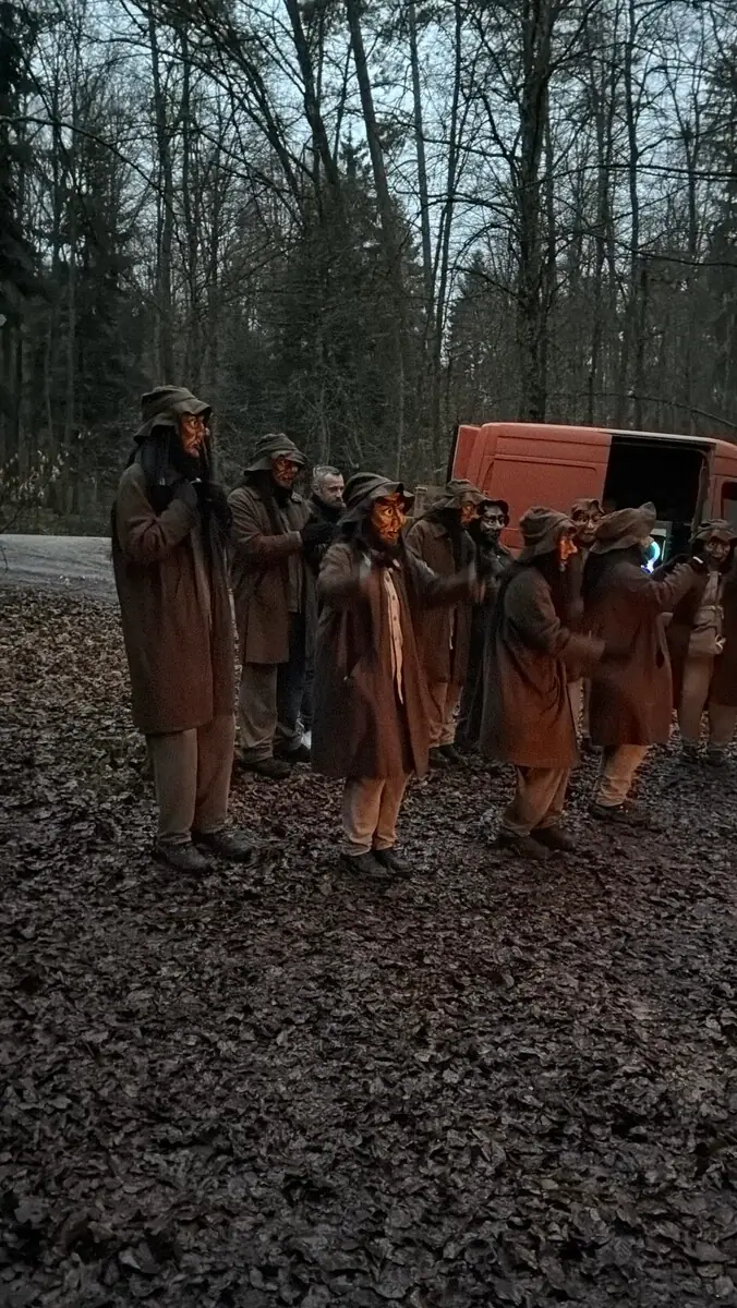 Gruppe der Hannikel in Lodenmänteln im Wald