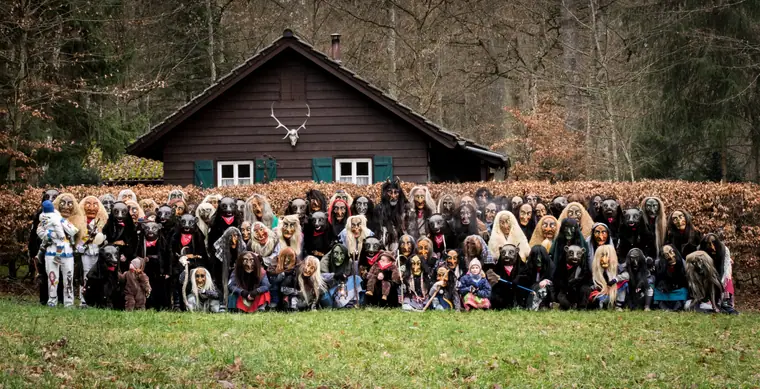 Großes Gruppenfoto der ganzen Zunft vor einer Hütte